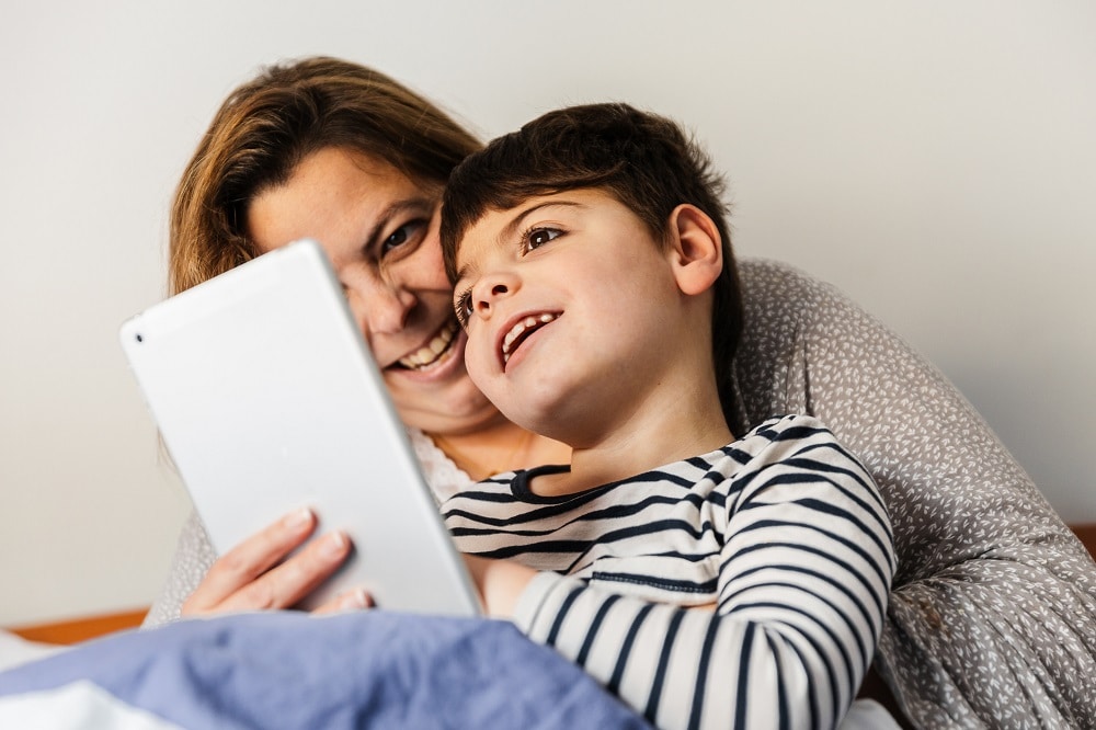 A mother and her son looking at a tablet.