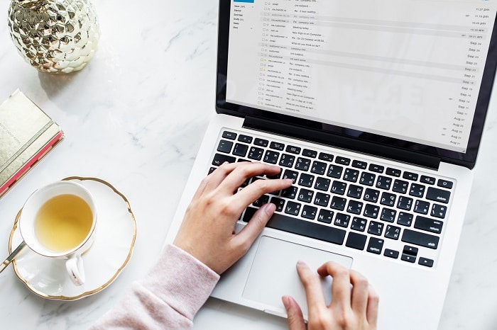 Aerial view of woman using a computer laptop and a cup of tea