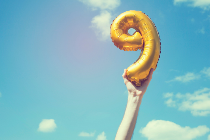 A gold number nine balloon, with the sky in the background.