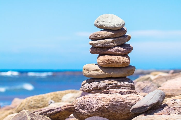 Rocks balancing in a pile on the beach.