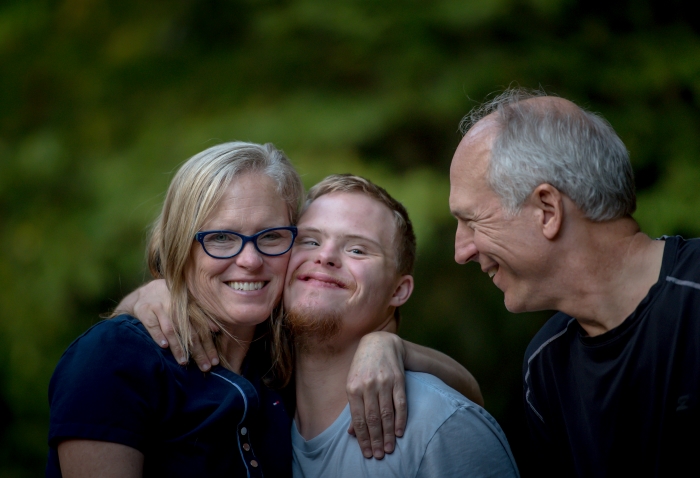 A young man with his mum and dad.