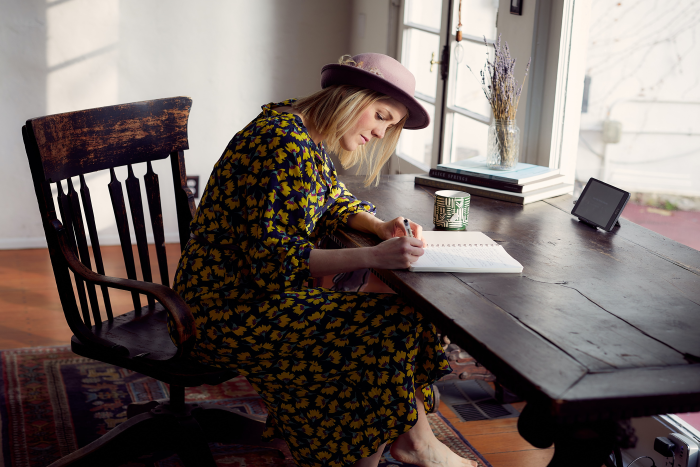 A person writes in a notebook at their desk.