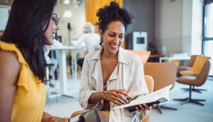 Two people looking at a book.
