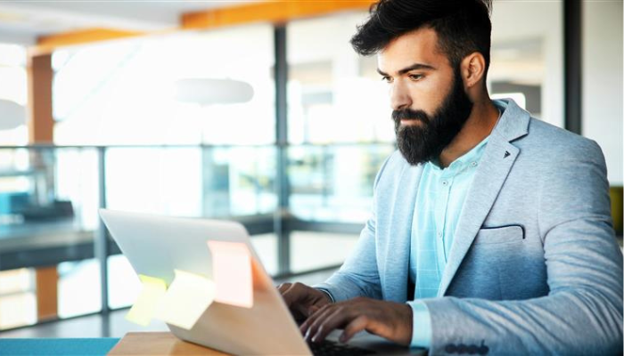 A person at a desk typing on a laptop.
