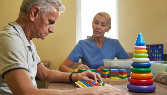 Two people at a table with wooden toys around them.